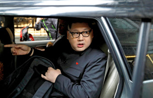 25日、警察に付き添われ車でホテルを離れる金正恩氏のそっくりさんの男性(ハノイ)=ロイター 25日、警察に付き添われ車でホテルを離れる金正恩氏のそっくりさんの男性(ハノイ)=ロイター
