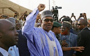 2月23日のナイジェリア大統領選で投票所に姿を見せ、支持者に手を上げるブハリ大統領=ロイター