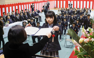 福島県飯舘村で8年ぶりに開かれた飯舘中学校の卒業式で、卒業証書を受け取る生徒(13日午前)=共同 福島県飯舘村で8年ぶりに開かれた飯舘中学校の卒業式で、卒業証書を受け取る生徒(13日午前)=共同