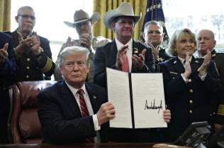 米ホワイトハウスで、議会の決議に拒否権を行使する文書に署名したトランプ大統領(15日、ワシントン)=UPI共同 米ホワイトハウスで、議会の決議に拒否権を行使する文書に署名したトランプ大統領(15日、ワシントン)=UPI共同