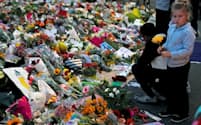 銃乱射事件の犠牲者を悼む人たち（18日、ニュージーランド・クライストチャーチ）