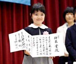 囲碁のプロ初段免状を手に笑顔を見せる仲邑菫さん(26日午後、東京都千代田区の日本棋院)=共同 囲碁のプロ初段免状を手に笑顔を見せる仲邑菫さん(26日午後、東京都千代田区の日本棋院)=共同