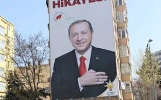 25日、トルコ・イスタンブールに掲げられたエルドアン大統領の巨大な選挙ポスター=共同