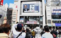 新元号「令和」を伝えるニュース画面を見る人たち（1日、東京都新宿区）