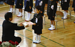 岡山県倉敷市で行われた市立箭田小の入学式で、校長から教科書を受け取る新入生(9日午前)=共同 岡山県倉敷市で行われた市立箭田小の入学式で、校長から教科書を受け取る新入生(9日午前)=共同
