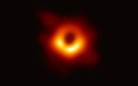 M87銀河の中心にある巨大ブラックホールを撮影した画像。中心の黒い部分がブラックホールの影（EHTコラボレーション提供）