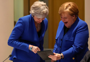メルケル独首相(右)とメイ英首相は同じような青色の服で首脳会議に臨んだ=ロイター メルケル独首相(右)とメイ英首相は同じような青色の服で首脳会議に臨んだ=ロイター