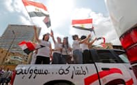 エジプトの国民投票で国旗を振る人たち（20日、カイロ）=ロイター