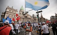 4日、政府の経済政策に反対してブエノスアイレス市内をデモ行進するアルゼンチンの労組メンバーら=ロイター