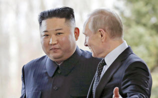 ロシアのプーチン大統領(右)に促される北朝鮮の金正恩委員長(25日、ロシア・ルースキー島)=AP ロシアのプーチン大統領(右)に促される北朝鮮の金正恩委員長(25日、ロシア・ルースキー島)=AP