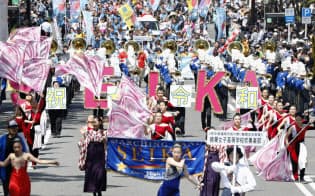 「博多どんたく港まつり」で、令和と書かれたプラカードを掲げて行進する精華女子高校の吹奏楽部(3日、福岡市) 「博多どんたく港まつり」で、令和と書かれたプラカードを掲げて行進する精華女子高校の吹奏楽部(3日、福岡市)