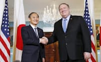 会談前にポンペオ国務長官(右)と握手する菅官房長官(9日、米ワシントンの国務省)=共同