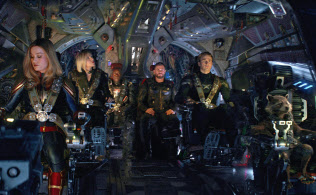 This image released by Disney shows, from left, Brie Larson, Scarlett Johansson, Don Cheadle, Chris Hemsworth, Chris Evans and the character Rocket, voiced by Bradley Cooper, in a scene from This image released by Disney shows, from left, Brie Larson, Scarlett Johansson, Don Cheadle, Chris Hemsworth, Chris Evans and the character Rocket, voiced by Bradley Cooper, in a scene from