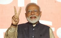 再選を確実にし、Vサインをするインドのモディ首相（23日、ニューデリー）=三村幸作撮影