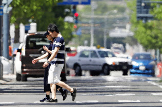 猛暑日となり、かげろうが立ち上る北海道帯広市の道路(26日)=共同 猛暑日となり、かげろうが立ち上る北海道帯広市の道路(26日)=共同