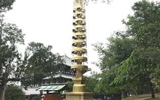 大阪万博「古河パビリオン」の七重塔先端の相輪。奥に見えるのが大仏殿（奈良市の東大寺）