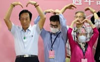 鴻海の郭董事長(左)はこわもてのイメージを払拭しようと躍起だ（11日、台北市内。がん治療に関するイベントで、患者やその家族と身ぶりでハートを作ってみせた）