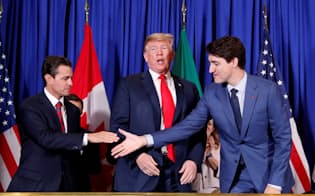 新NAFTA協定合意で署名するトランプ米大統領(中)ら（2018年11月、ブエノスアイレス）=ロイター