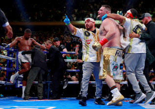 番狂わせの勝利を挙げて喜ぶアンディ・ルイス・ジュニアと陣営の人たち=ロイター 番狂わせの勝利を挙げて喜ぶアンディ・ルイス・ジュニアと陣営の人たち=ロイター