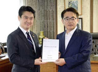 全国知事会の外国人就労拡大制度に関する提言書を山下法相(左)に手渡す大村秀章愛知県知事(7日、法務省)=共同 全国知事会の外国人就労拡大制度に関する提言書を山下法相(左)に手渡す大村秀章愛知県知事(7日、法務省)=共同