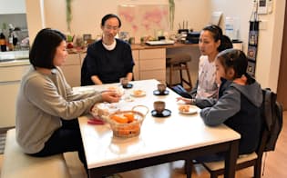戸建て型の民泊施設で住人の日本人女性(左)と交流するタイ人一家