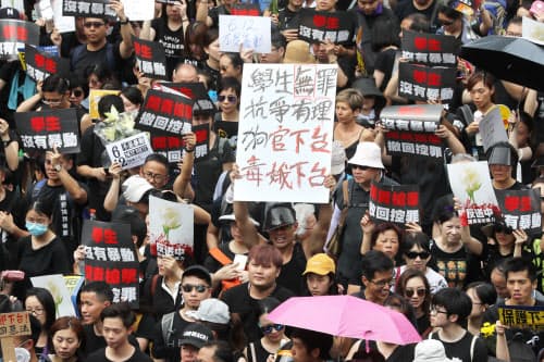 「逃亡犯条例」改正案に反対し、香港中心部をデモ行進する人たち(16日、香港)=三村幸作撮影