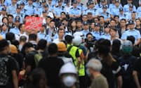 立法会前で警察（奥）とにらみ合うデモ隊（17日午前、香港）=三村幸作撮影