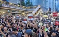 「逃亡犯条例」改正案に反対し、香港中心部をデモ行進する人たち（16日、香港）=三村幸作撮影