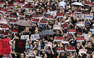 中国本土への容疑者引き渡しを可能にする「逃亡犯条例」改正案の撤回を求めデモ行進する人たち(16日、香港)=共同 中国本土への容疑者引き渡しを可能にする「逃亡犯条例」改正案の撤回を求めデモ行進する人たち(16日、香港)=共同