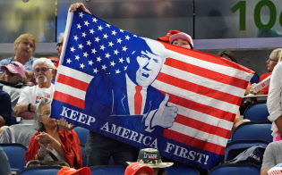 オーランドの大規模集会で、トランプ氏が描かれた国旗を掲げる支持者=ロイター オーランドの大規模集会で、トランプ氏が描かれた国旗を掲げる支持者=ロイター