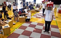 村田製作所の体験型教室。ロボット役の社員が児童の指示通りに動く（京都府長岡京市）