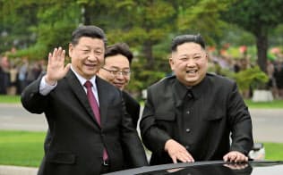 平壌市内へ向かう途中、車上から沿道の市民に笑顔で手を振る中国の習近平国家主席(左)と北朝鮮の金正恩委員長(20日)=朝鮮中央通信・共同 平壌市内へ向かう途中、車上から沿道の市民に笑顔で手を振る中国の習近平国家主席(左)と北朝鮮の金正恩委員長(20日)=朝鮮中央通信・共同