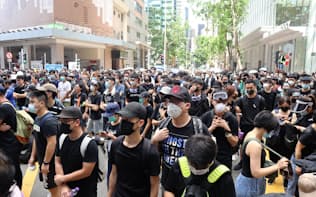 21日、香港警察本部の前で抗議する若者ら