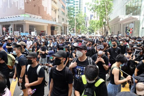 21日、香港警察本部の前で抗議する若者ら