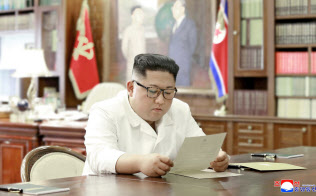 トランプ米大統領から送られた親書を読む金正恩委員長=朝鮮中央通信・ロイター トランプ米大統領から送られた親書を読む金正恩委員長=朝鮮中央通信・ロイター