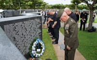 米国戦没者の名前が刻まれた刻銘板で祈りをささげる在沖米国関係者（23日、沖縄県糸満市）
