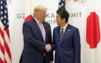 トランプ米大統領と握手する安倍首相（28日、大阪市）=ロイター