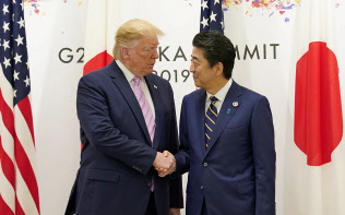 トランプ米大統領と握手する安倍首相(28日、大阪市)=ロイター トランプ米大統領と握手する安倍首相(28日、大阪市)=ロイター