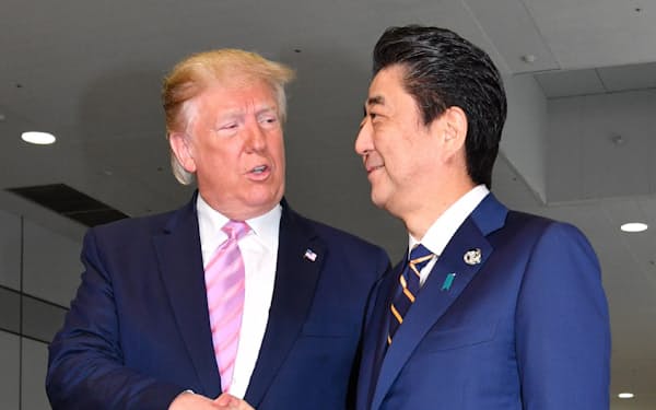 トランプ米大統領を出迎え握手する安倍首相(6月28日、大阪市)