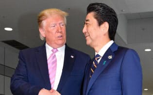 トランプ米大統領を出迎え握手する安倍首相（６月28日、大阪市）