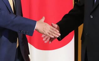 安倍晋三首相と中国の習近平国家主席（右）の握手（27日、大阪市）
