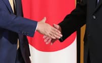 安倍晋三首相と中国の習近平国家主席（右）の握手（27日、大阪市）