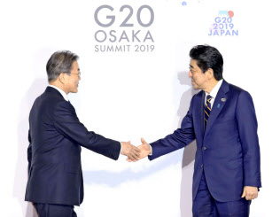 G20大阪サミットで韓国の文在寅大統領(左)を迎える安倍首相(28日、大阪市)=代表撮影 G20大阪サミットで韓国の文在寅大統領(左)を迎える安倍首相(28日、大阪市)=代表撮影