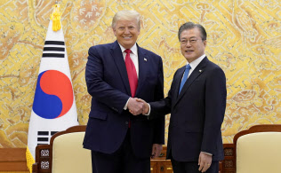 30日、ソウルの青瓦台で、文在寅大統領と握手するトランプ米大統領=ロイター 30日、ソウルの青瓦台で、文在寅大統領と握手するトランプ米大統領=ロイター