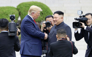 板門店の北朝鮮側で握手するトランプ米大統領(中央左)と北朝鮮の金正恩朝鮮労働党委員長(30日)=聯合・共同 板門店の北朝鮮側で握手するトランプ米大統領(中央左)と北朝鮮の金正恩朝鮮労働党委員長(30日)=聯合・共同