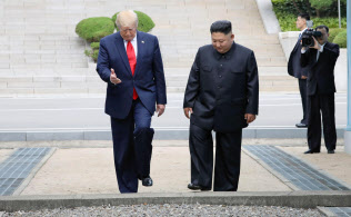 板門店で対面し、北朝鮮側から軍事境界線を越えるトランプ米大統領(左)と北朝鮮の金正恩朝鮮労働党委員長(30日)=聯合・共同 板門店で対面し、北朝鮮側から軍事境界線を越えるトランプ米大統領(左)と北朝鮮の金正恩朝鮮労働党委員長(30日)=聯合・共同