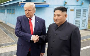 板門店で面会し、握手するトランプ米大統領(左)と北朝鮮の金正恩委員長(30日)=ロイター 板門店で面会し、握手するトランプ米大統領(左)と北朝鮮の金正恩委員長(30日)=ロイター