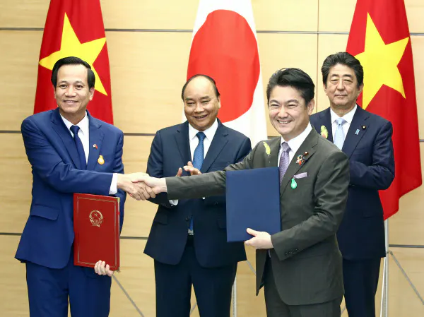 文書を交換する山下法相(手前右)とベトナムのズン労働・傷病兵・社会問題相(手前左)を見守るベトナムのフック首相(左から2人目)と安倍首相(1日、首相官邸)