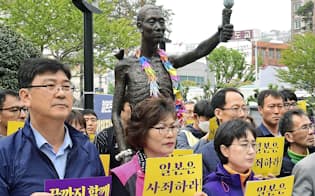 徴用工問題で政府は韓国への厳しい対抗措置に踏みきった(1日、韓国・釜山の徴用工像の周辺で開かれた集会)=共同