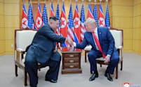 6月30日、板門店の韓国側施設で北朝鮮の金正恩朝鮮労働党委員長（左）と握手するトランプ米大統領=朝鮮中央通信・共同